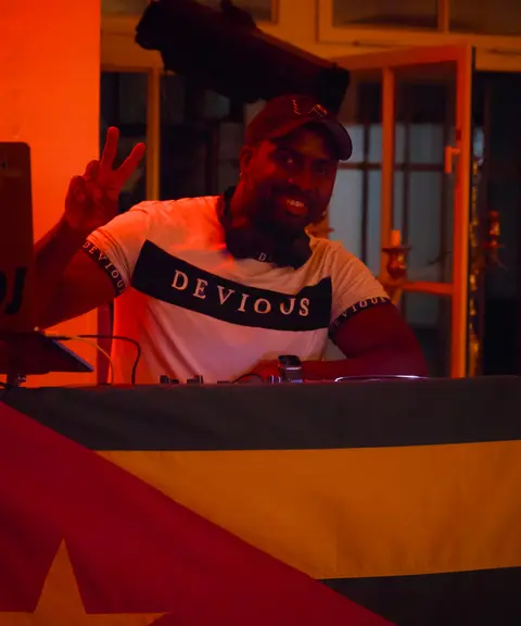 DJ legt kubanische Salsa auf, im Hintergrund die kubanische Flagge