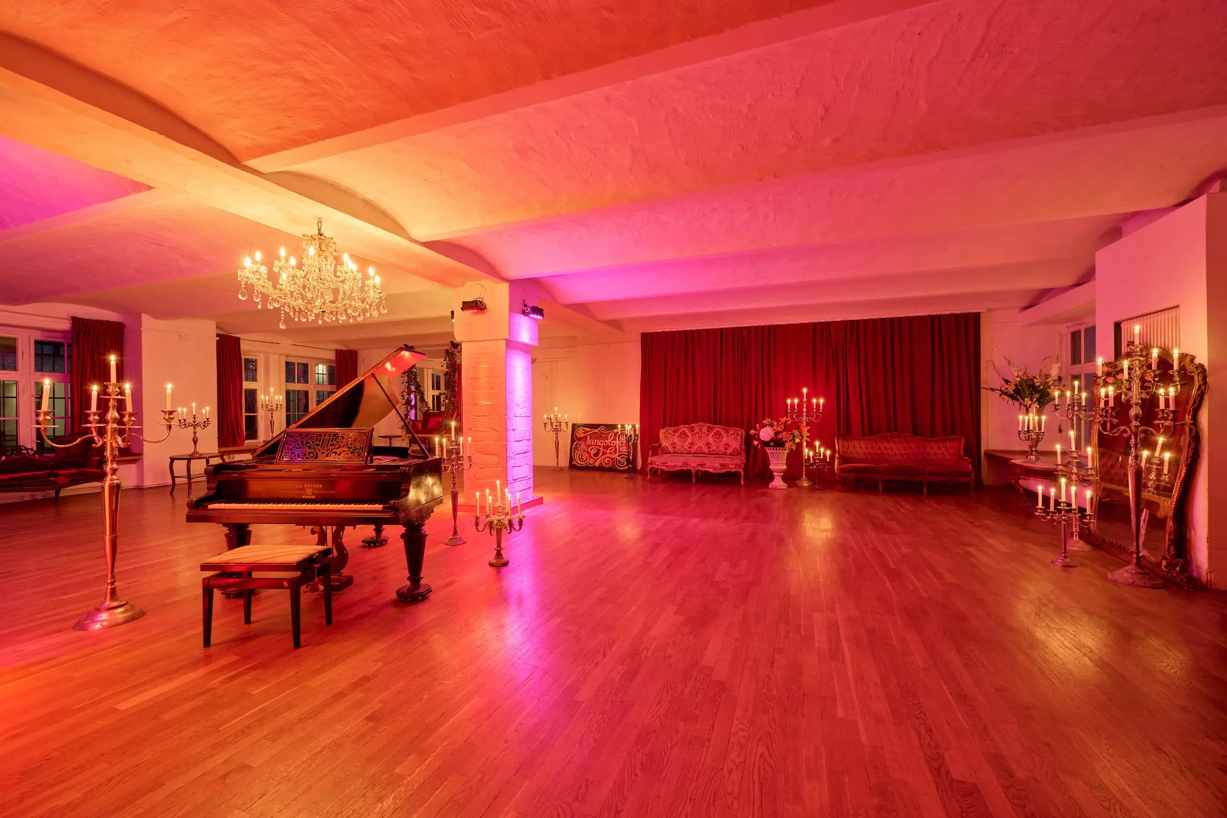 Der Saal am Abend, in warmes rotes Licht getaucht
